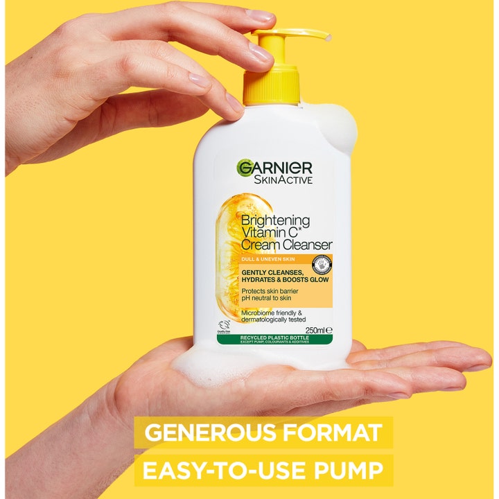 Garnier Skin Active Vitamin C Cream Cleanser 250 ml ansiktsrens gir glød i hvit pumpeflaske med skum i en hånd