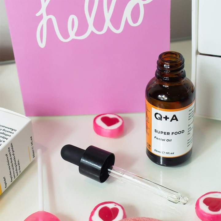Q+A Super Food Facial Oil 30 ml nærende ansiktsolje i åpen brun glassflaske med pipette og rosa bakgrunn