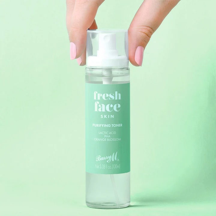 Barry M Fresh Face Skin Purifying Toner 100 ml rensende ansiktsvann med melkesyre i en klar sprayflaske holdt av en hånd