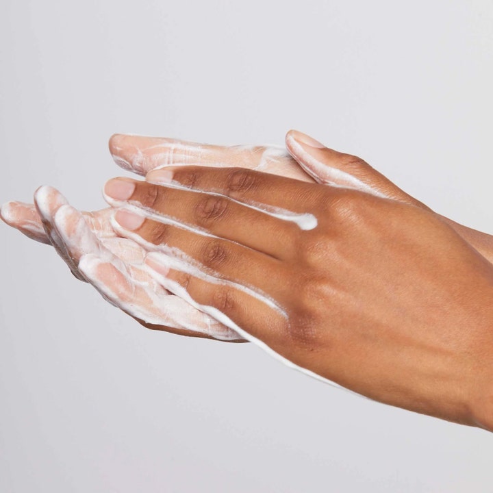 Dermalogica Discover Healthy Skin Kit rensende ansiktspleie som viser hvit kremet tekstur som skummer i hendene