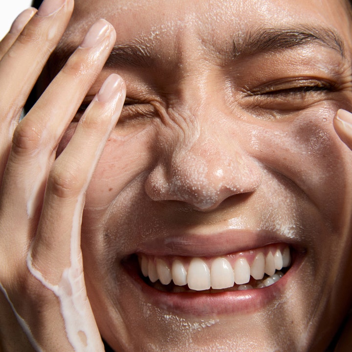The INKEY List Hydrating Cream to Milk Cleanser 50 ml fuktighetsgivende ansiktsrengjøring påført i et smilende ansikt.