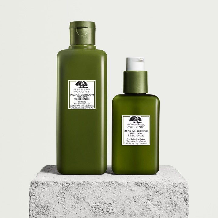 Origins Dr. Weil Mega-Mushroom 200 ml beroligende ansiktspleie i mørkegrønne flasker på en grå steinblokk