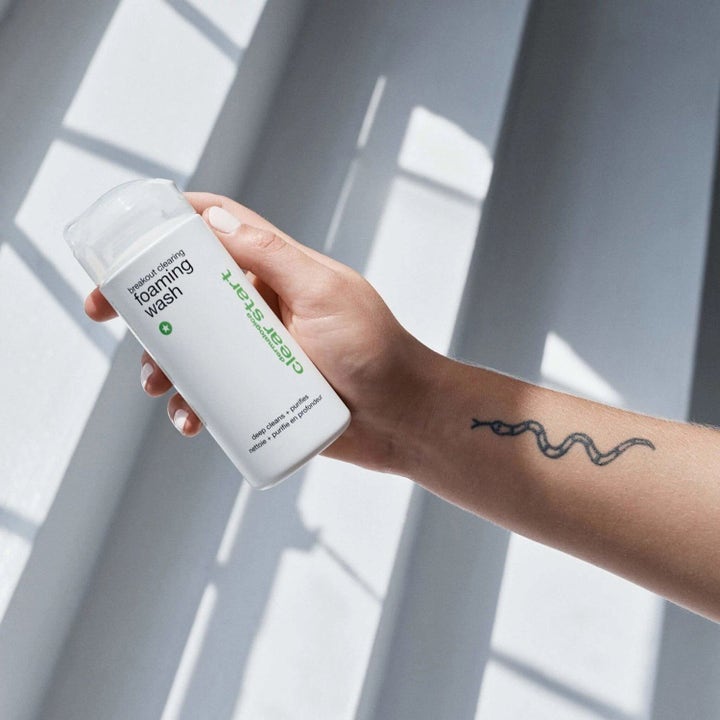 Dermalogica Clear Start Breakout Clearing Foaming Wash dyprensende ansiktsvask holdes av en hånd med tatovering