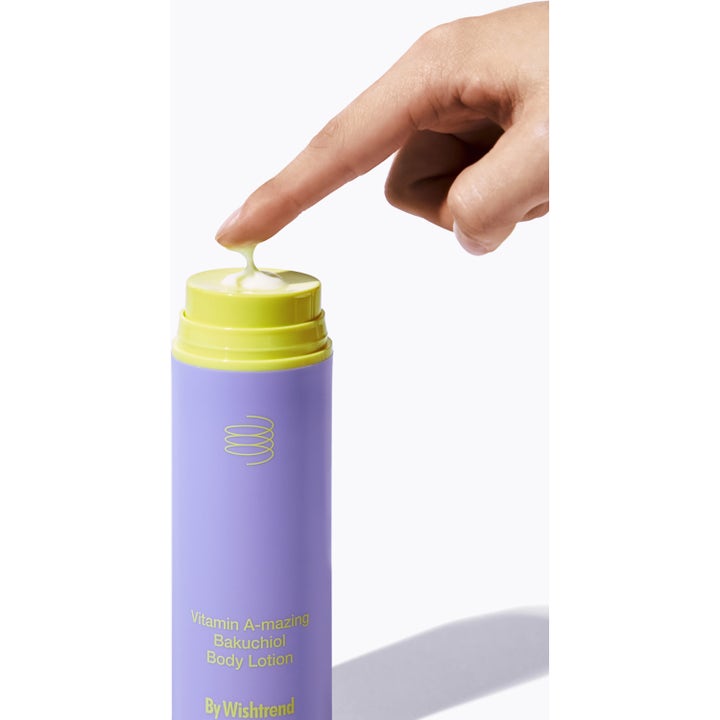 By Wishtrend Vitamin A-mazing Bakuchiol Body Lotion 150 g lilla flaske med gul kremet tekstur som berøres av en finger
