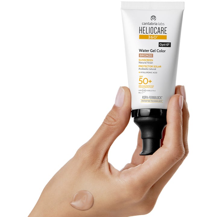 Heliocare Water Gel Color Bronze 50 ml solkrem i hvit tube med pumpe og farget tekstur på en hånd