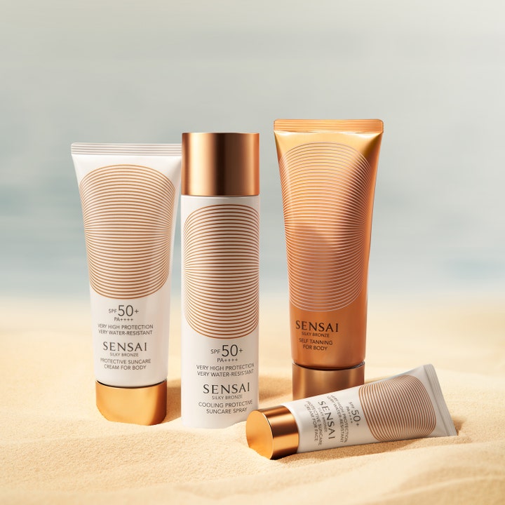 Sensai Silky Bronze Protective Cream Face SPF50+ 50 ml ansiktssolkrem i hvit tube med gullkork liggende på sand.