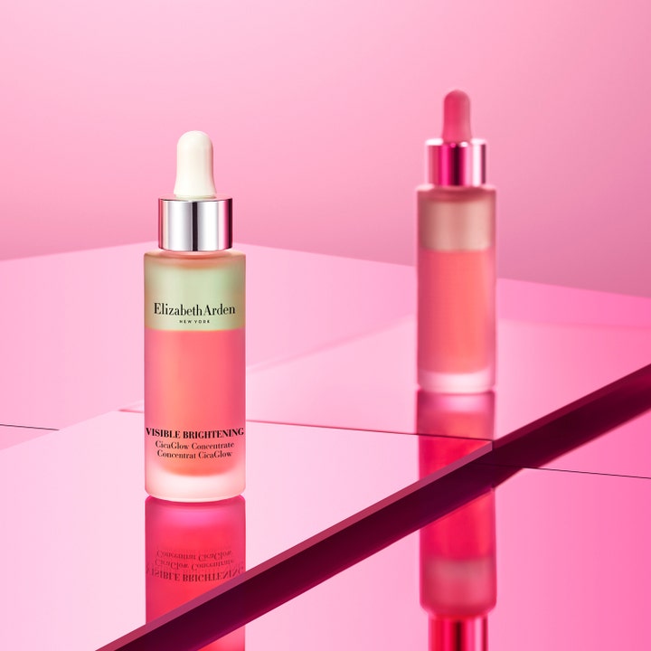 Elizabeth Arden Visible Brightening Cica Glow 30 ml serum gir glød i frostet glassflaske med hvit pipette på rosa speil.