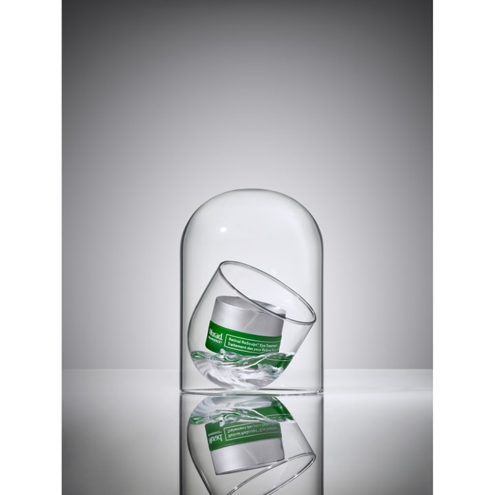 Murad Retinal ReSculpt Eye Lift Treatment 15 ml oppstrammende øyekrem i sølvkrukke plassert inni en glasskuppel.