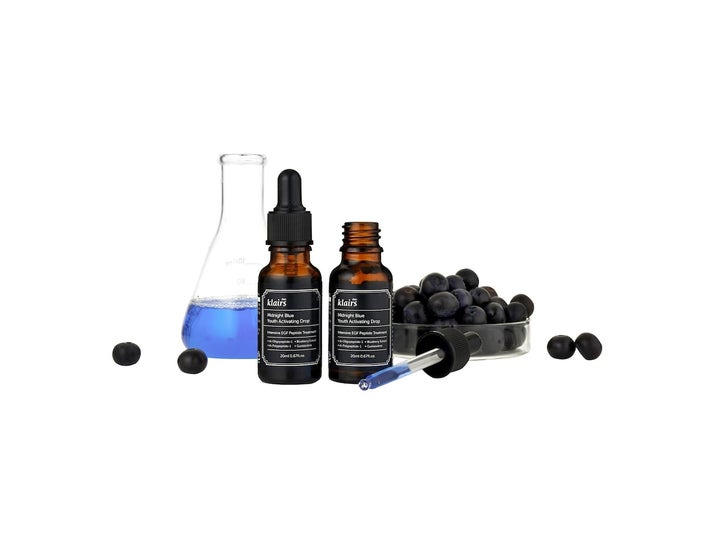 Klairs Midnight Blue Youth Activating Drop 20 ml serum med peptider i brune glassflasker med blå væske og friske blåbær.