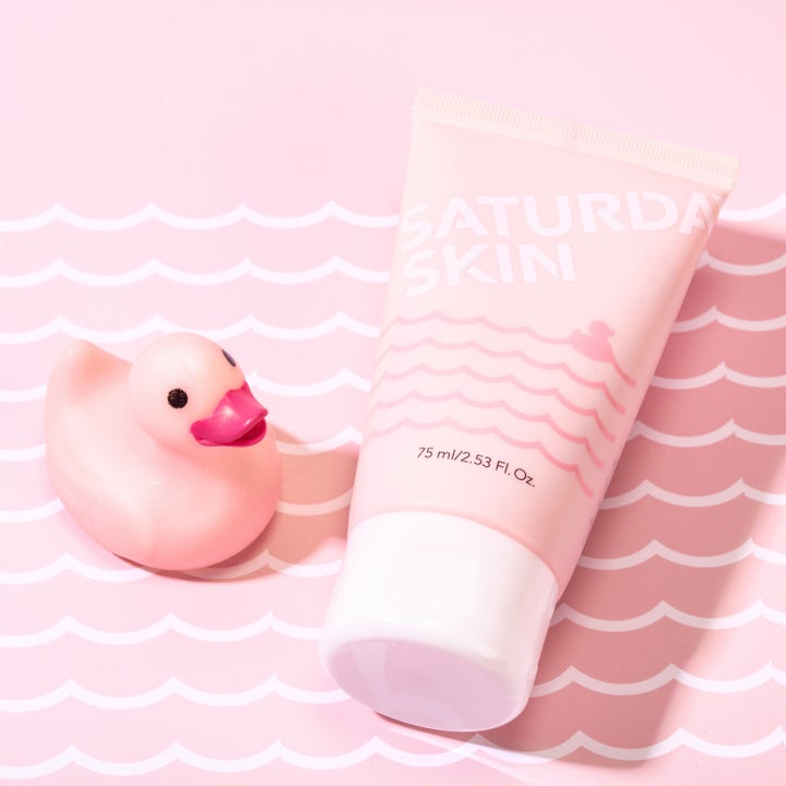 Saturday Skin Rub-a-Dub Refining Peel Gel 75 ml eksfolierende ansiktsskrubb i rosa tube ved siden av en rosa badeand