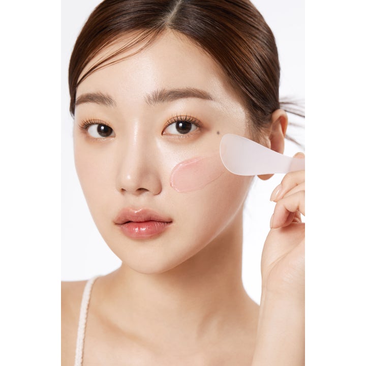 Medicube Collagen Jelly Cream 110 ml fuktighetsgivende ansiktskrem rosa gelé påføres med hvit spatel for glød