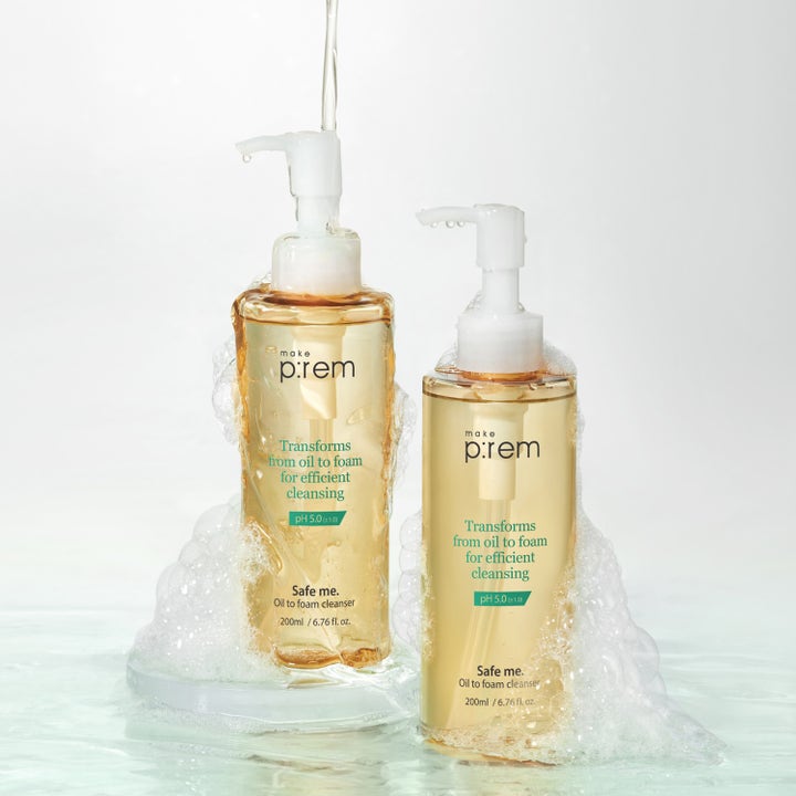 Make Prem Safe Me Oil To Foam Cleanser 200 ml skånsom rens i pumpeflasker omgitt av hvitt skum og vann