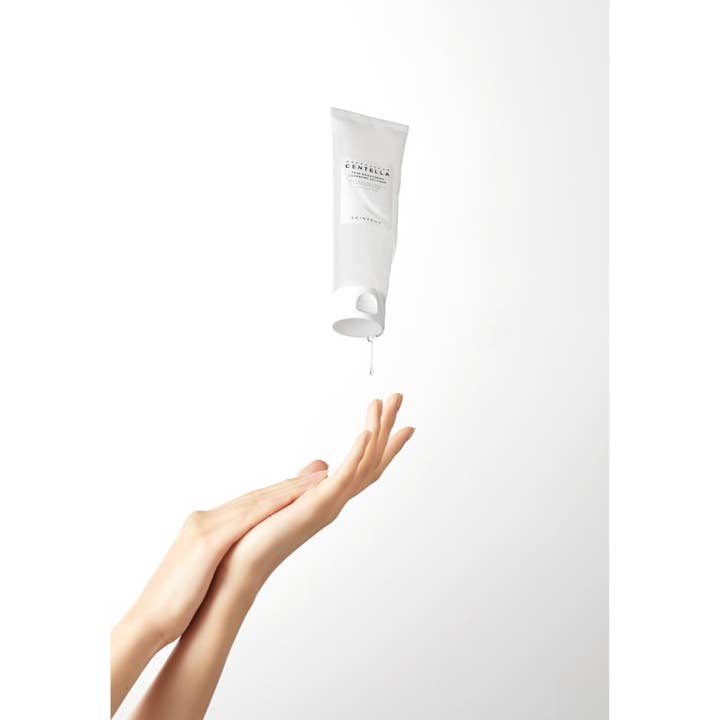 SKIN1004 Madagascar Centella 125 ml gelrens som drypper fra en hvit tube ned i en åpen håndflate