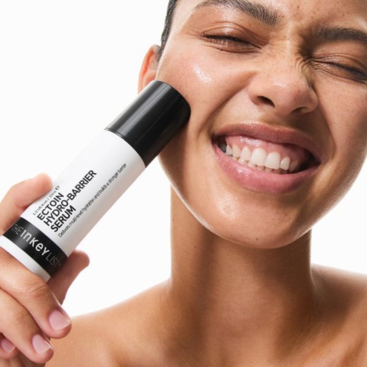 The INKEY List Ectoin Hydro-Barrier Serum 30 ml styrkende ansiktsserum i pumpeflaske som holdes mot kinnet til en person.