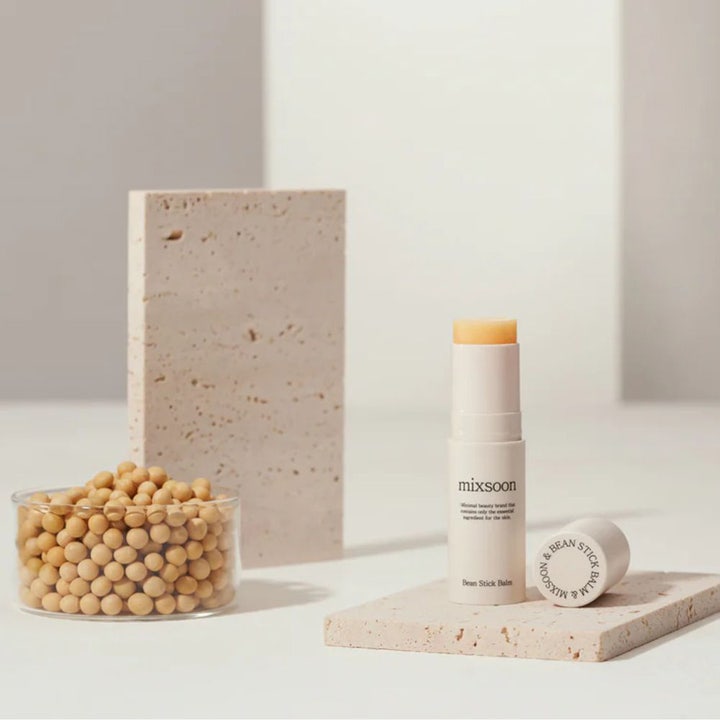 Mixsoon Bean Stick Balm 11,5 ml fuktighetsgivende dagkrem i stiftformat ved siden av en skål med soyabønner.