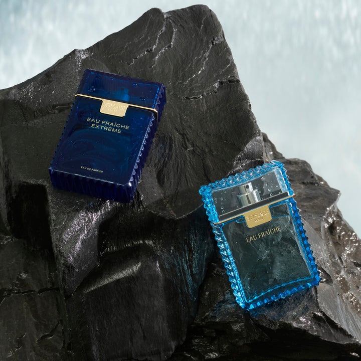 Versace Eau Fraiche Extreme 75 ml herreduft i blå glassflasker på våte, mørke steiner ved vann