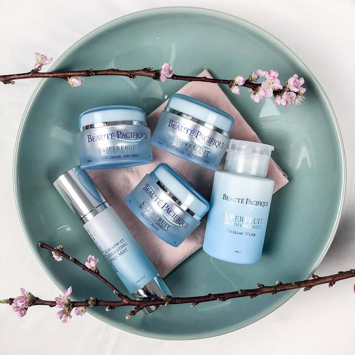 Beauté Pacifique Superfruit Enforcement Day Cream 50 ml fuktighetskrem i lyseblå krukke omgitt av kirsebærblomster.