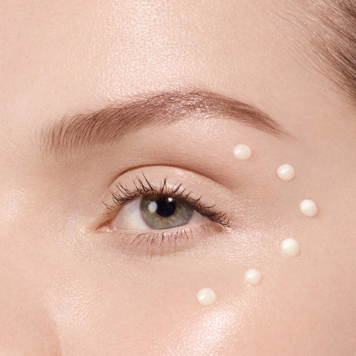 Lancôme Absolue The Eye Cream 20 ml øyekrem påføres i små hvite dråper i en bue rundt øyeområdet.