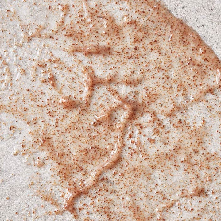 Meraki Footscrub Calm Cedar 100 ml eksfolierende fotpleie med geltekstur og små brune korn som fjerner død hud.