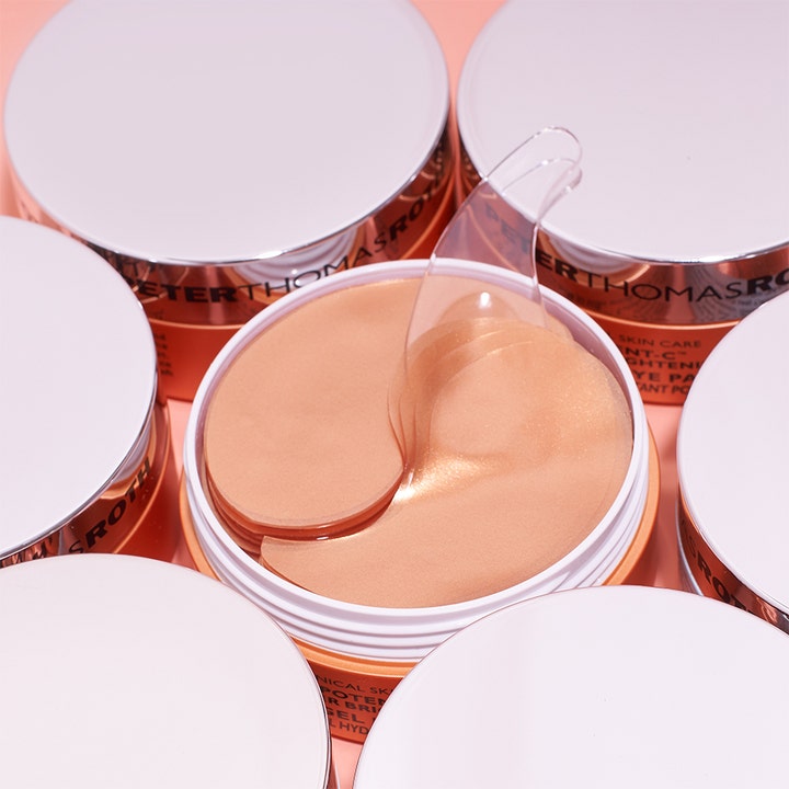Peter Thomas Roth Potent-C Eye Patches 90 g opplysende øyemasker viser skinnende gylne gel-patches i en krukke med spatel.
