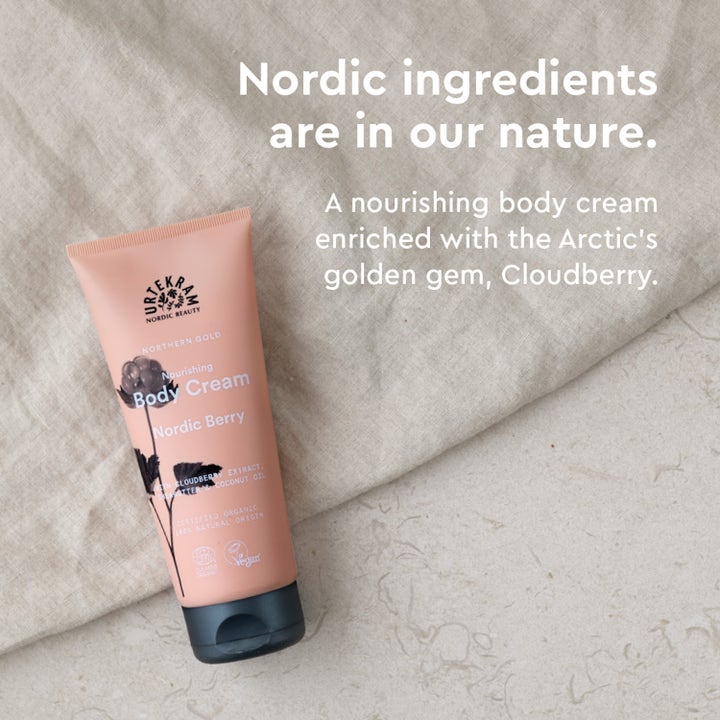Urtekram Nordic Berry Body Cream 200 ml gir næring med multer i ferskenfarget tube plassert på lyst linstoff.