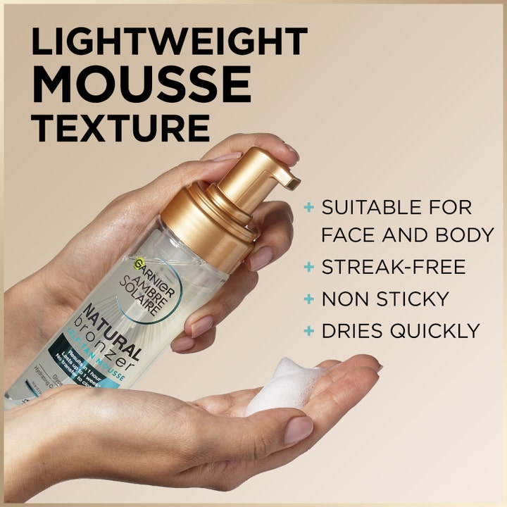 Garnier Ambre Solaire Natural Bronzer 200 ml selvbruning med lett hvit mousse i hånden fra en gullfarget pumpe