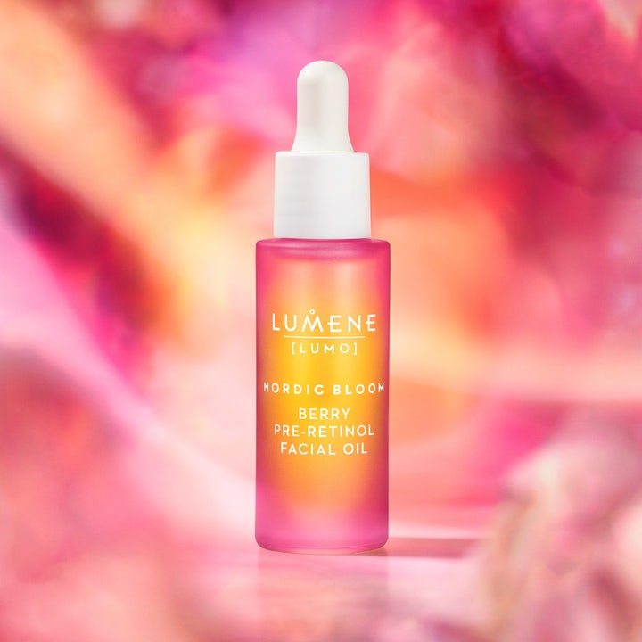 Lumene Nordic Bloom Berry Pre-Retinol Facial Oil 30 ml i rosa glassflaske med hvit pipette mot blomstret bakgrunn