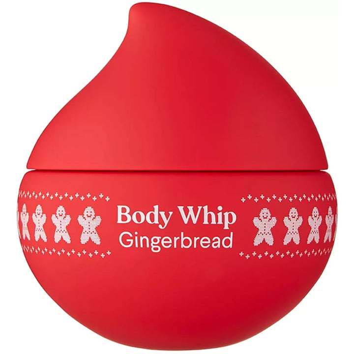 Body Whip Gingerbread fuktighetsgivende kroppskrem i rød dråpeformet krukke dekorert med hvite pepperkakemenn.