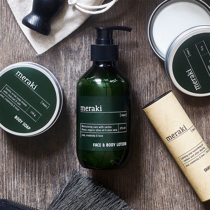 Meraki Face & Body Lotion For Men 275 ml fuktighetsgivende krem i mørk pumpeflaske omgitt av barberutstyr