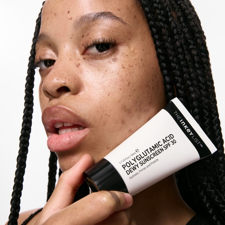The INKEY List Polyglutamic Acid Dewy Sunscreen 50 ml fuktighetsgivende solkrem vist mot ansiktet til en person.
