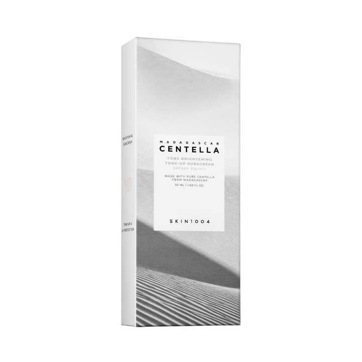 SKIN1004 Madagascar Centella Tone Brightening Tone-Up Sunscreen 50 ml glødgivende solkrem i hvit eske med sanddyner.