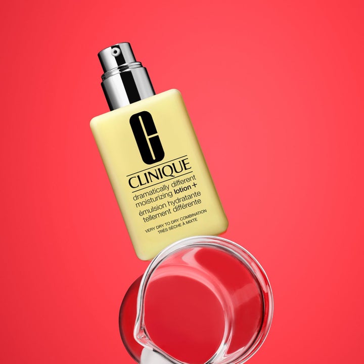 Clinique Dramatically Different Moisturizing Lotion+ 225 ml fuktighetskrem i gul flaske med sølvpumpe mot rød bakgrunn
