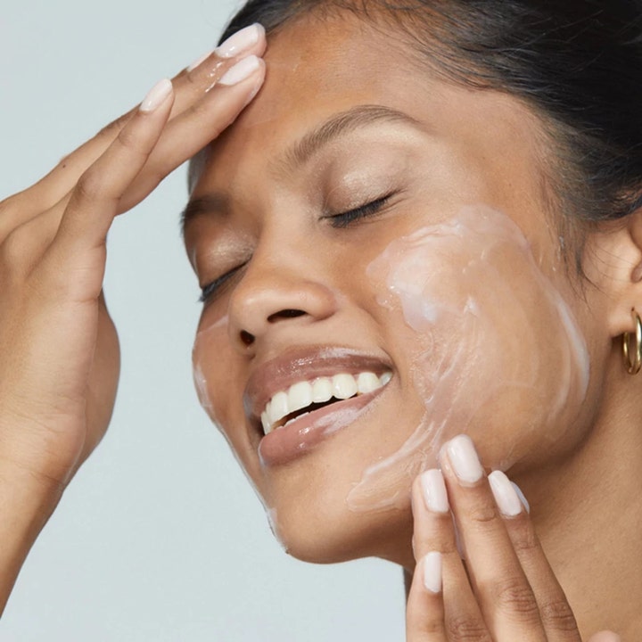 Dermalogica UltraCalming Cleanser 500 ml beroligende ansiktsrengjøring i bruk på en smilende kvinne.