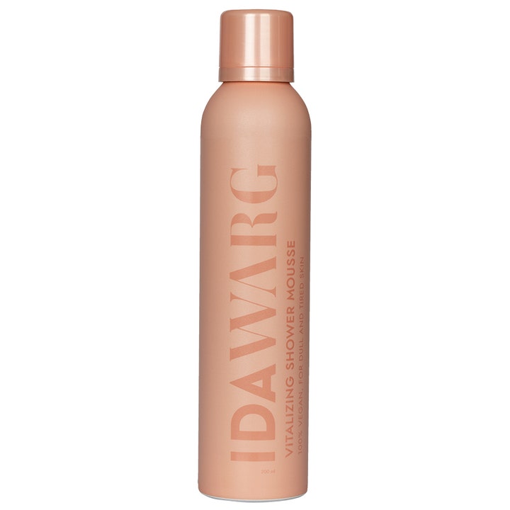 Ida Warg Vitalizing Shower Mousse 200 ml oppfriskende dusjskum som gir glød i en ferskenfarget sprayflaske.
