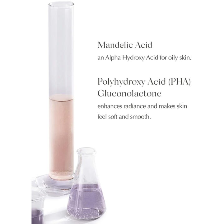 Exuviance Night Corrector 50 g nattkrem med mandelsyre og PHA som gir glød, vist med laboratorieglass og ingredienstekst.
