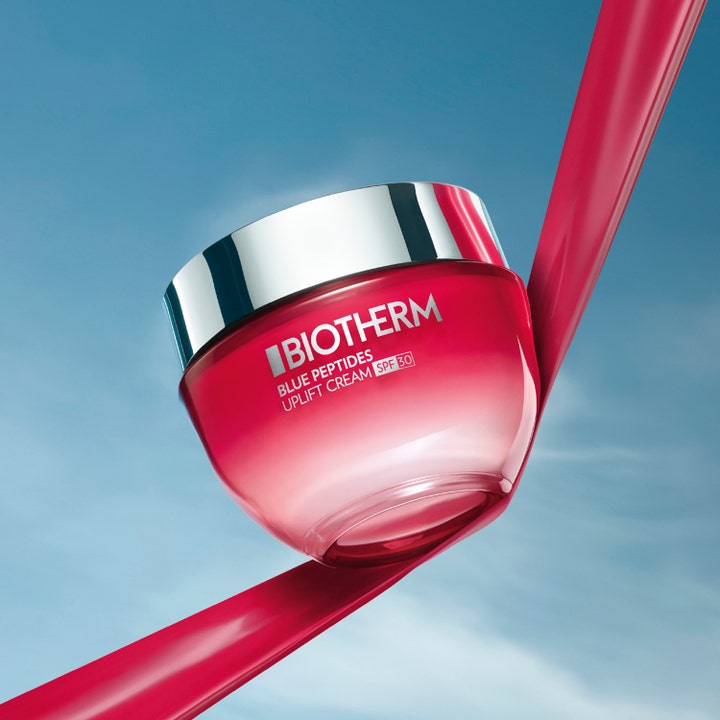 Biotherm Blue Peptides Uplift Cream 50 ml fuktighetskrem med SPF 30 i rød glasskrukke med sølvlokk mot blå himmel