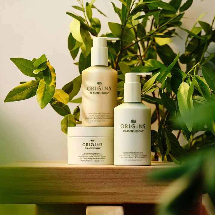 Origins Plantfusion Conditioning Hand & Body Wash 200 ml dusjsåpe i flaske med pumpe foran grønne blader