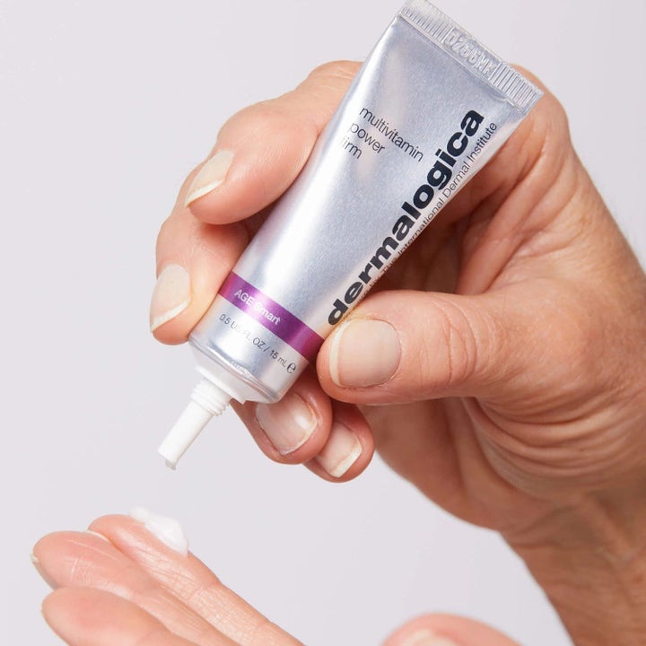 Dermalogica MultiVitamin Power Firm 15 ml oppstrammende øyekrem i sølvfarget tube som påføres huden med hvit krem.