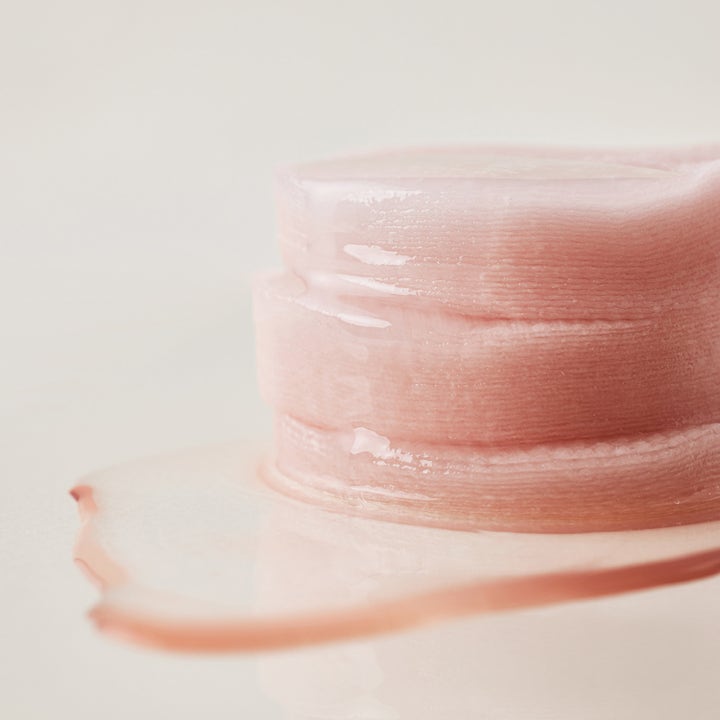 House of Hur Clearing Skin Prep Essence Pad 140 ml eksfolierende pads i stabel dynket i fuktighetsgivende rosa væske.