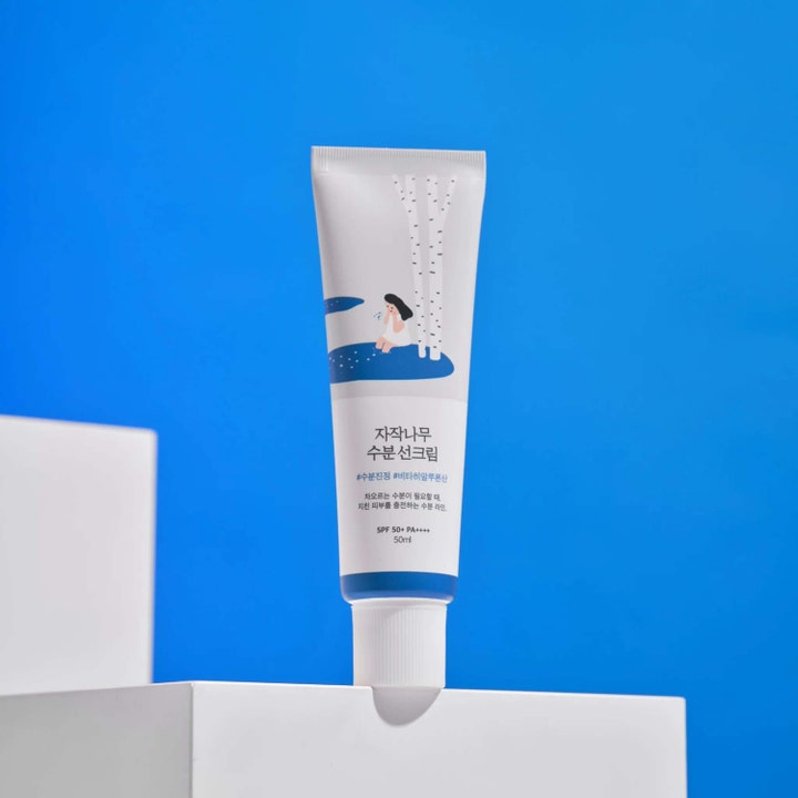 Round Lab Birch Juice Moisturizing Sunscreen 50 ml i hvit tube på blå bakgrunn gir fukt og SPF 50.
