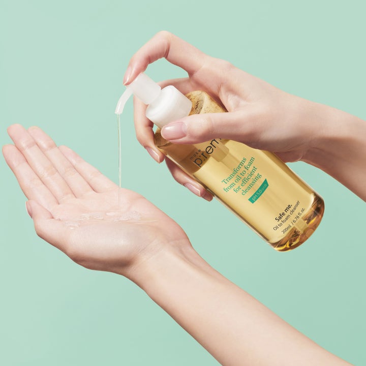 Make Prem Safe Me Oil To Foam Cleanser 200 ml ansiktsrens pumpes ut som en gyllen olje i en åpen håndflate.