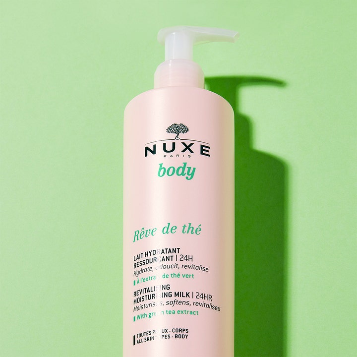 Nuxe Body Reve De Thé 400 ml fuktighetsgivende body lotion i lyserosa pumpeflaske mot grønn bakgrunn