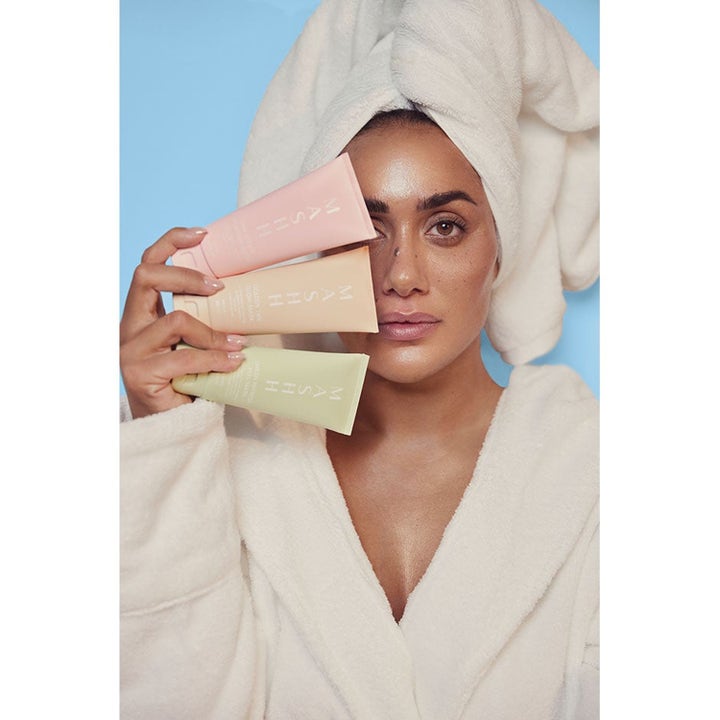 MASHH Mask Set Green Refresh og Pink Repair ansiktsmasker for glød. Kvinne i hvit badekåpe holder tre fargede tuber.