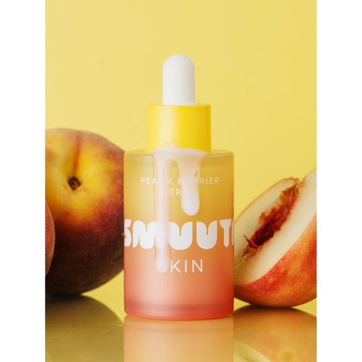 Smuuti Skin Peach Barrier Serum 30 ml styrkende ansiktsserum i ferskenfarget glassflaske med hvit tekstur og fersken