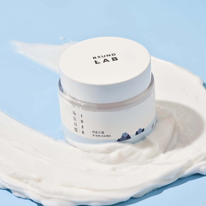 Round Lab 1025 Dokdo Cream 80 ml fuktighetsgivende ansiktskrem i hvit krukke plassert i fyldig hvit tekstur