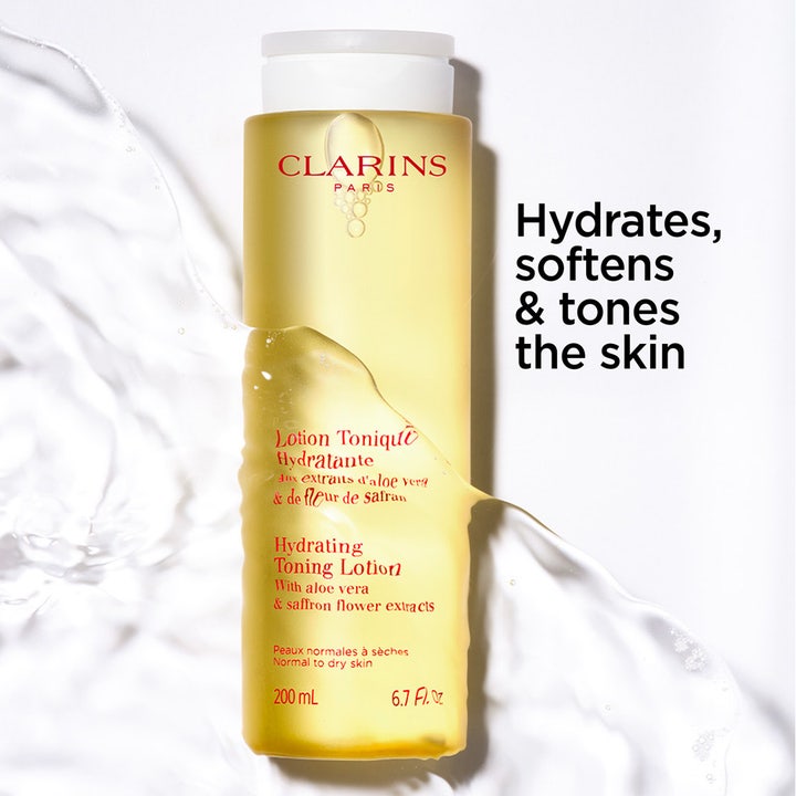 Clarins Hydrating Toning Lotion 400 ml ansiktsvann i gul plastflaske omgitt av vannsprut