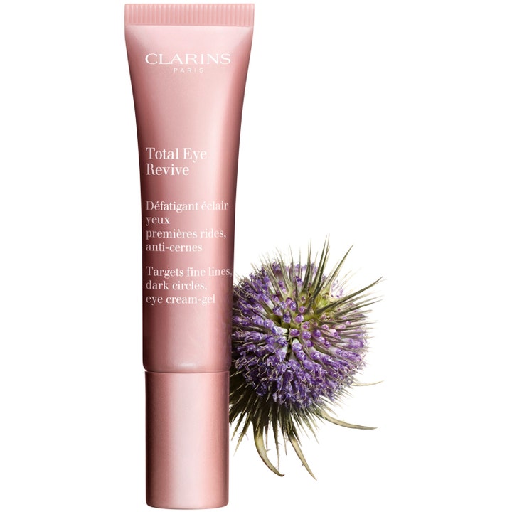 Clarins Total Eye Revive 15 ml øyekrem mot mørke ringer i rosa tube ved siden av en lilla tistelknopp