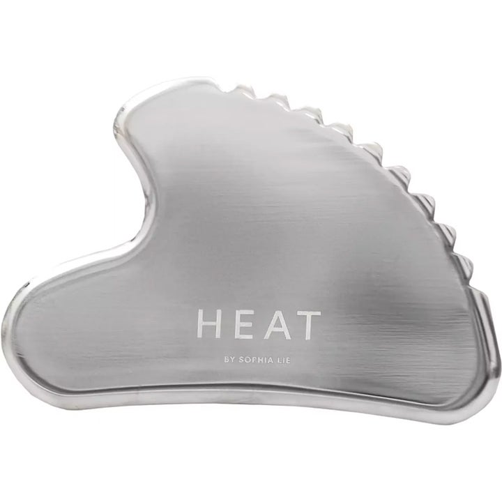 Heat by Sophia Lie Gua Sha massasjeverktøy i rustfritt stål gir ansiktet glød med sin bølgede form.
