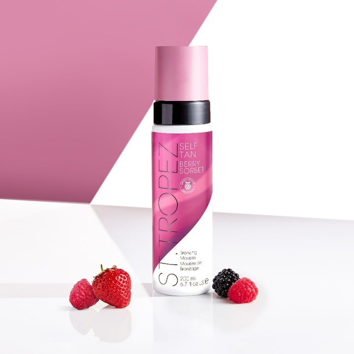 St.Tropez Self Tan Berry Sorbet Bronzing Mousse 200 ml selvbruning for glød i hvit flaske med rosa kork og friske bær.
