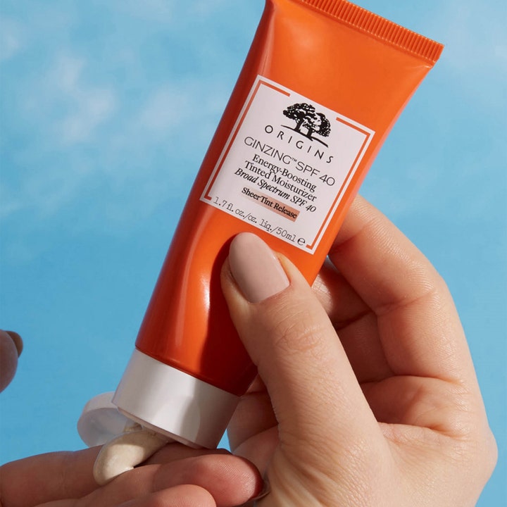 Origins GinZing SPF40 Energy-Boosting Tinted Moisturizer 50 ml farget dagkrem i oransje tube som klemmes ut i hånden